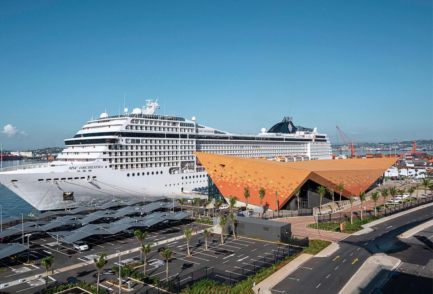 Large MSC cruise ship docked at a tropical port with turquoise water